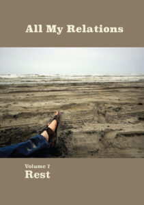 Cover art: A man’s blue-jean-clad, legs and sandal-shod feet extend across the flat sandy beach from the lower left corner toward calm ocean waves in the distance. 